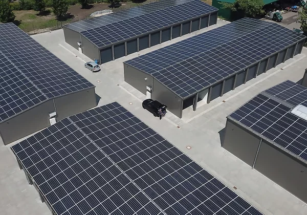 Ein großer Garagenpark mit zahlreichen Garagen aus der Vogelperspektive, auf deren Dächern großflächige Solarmodule installiert sind.